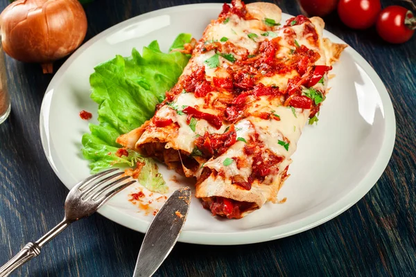 Traditionele Mexicaanse enchiladas met kippenvlees, pikante tomatensaus en kaas op een plaat — Stockfoto