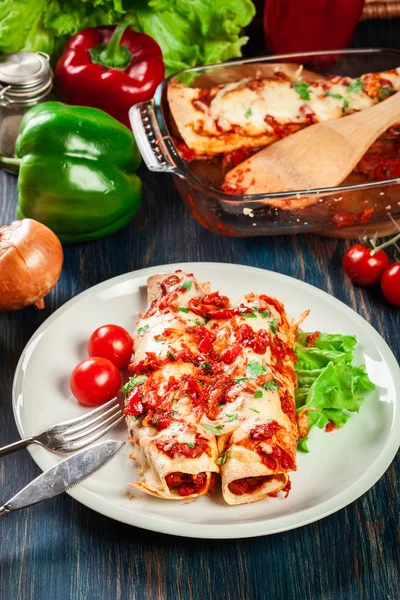 Tradiční mexické enchiladas s kuřecím masem, pikantní rajčatovou omáčkou a sýrem na talíři — Stock fotografie