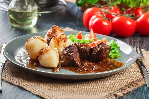 Stufato di carne di maiale servito con patate e insalata di verdure — Foto Stock