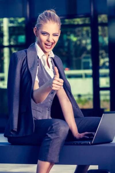 Jonge aantrekkelijke zakenvrouw met laptop in een stedelijke omgeving. Bedrijfsconcept — Stockfoto