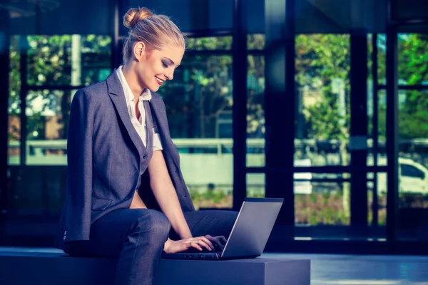 Joven mujer de negocios atractiva utilizando el ordenador portátil en un entorno urbano. Concepto empresarial — Foto de Stock