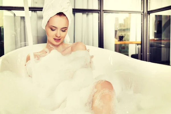 젊은 아름 다운 빨간 머리 여자는 거품 목욕 — 스톡 사진