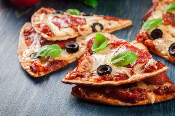 Segmenten van de pizza pepperoni met olijven — Stockfoto