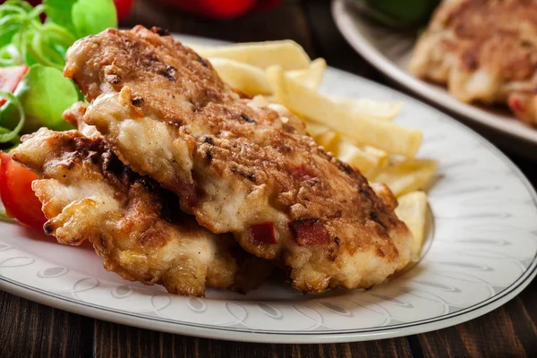 Chicken medallions with red peppers served with chips — Stock Photo, Image