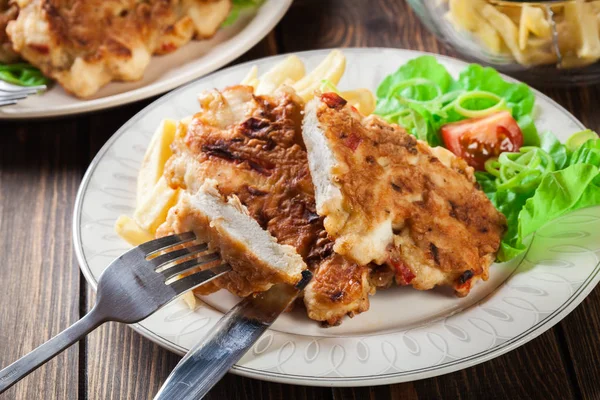 Medallones de pollo con pimientos rojos servidos con papas fritas —  Fotos de Stock