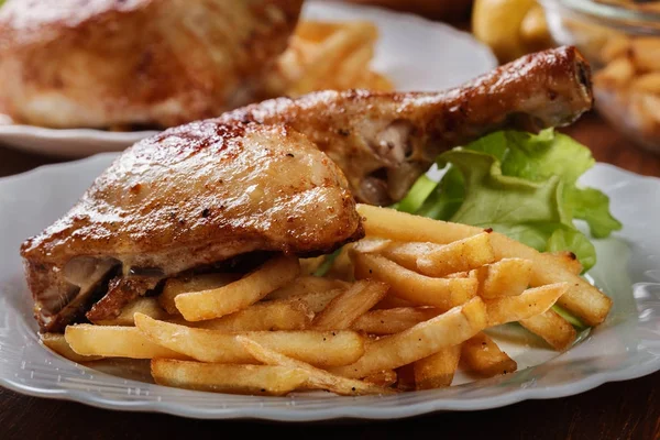 Pečená kuřecí stehna s hranolky a salát — Stock fotografie