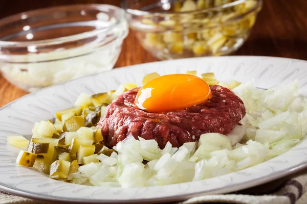 Filete tartar con yema de huevo, cebollas y encurtidos — Foto de Stock