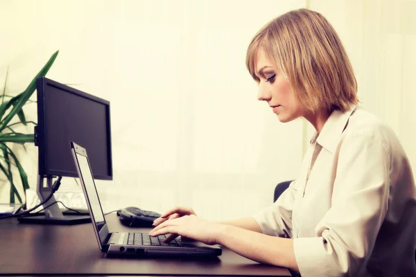 Mujer de negocios rubia trabajando en la computadora en la oficina —  Fotos de Stock