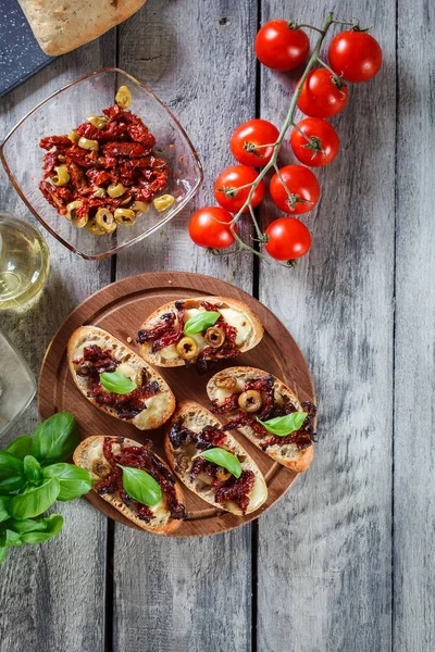 Vorspeise Bruschetta mit sonnengetrockneten Tomaten, Oliven und Mozarel — Stockfoto