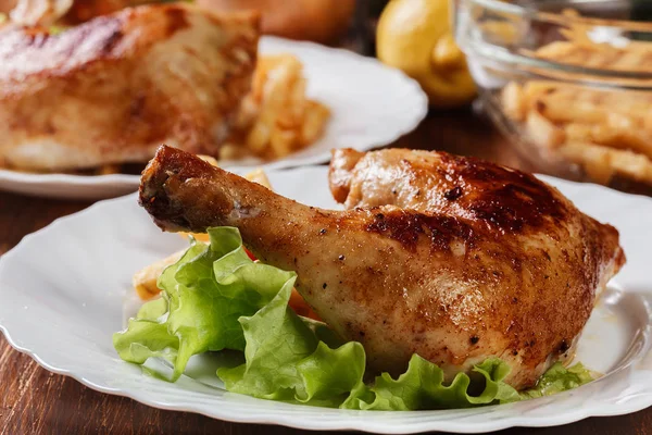 Roasted chicken legs with french fries and lettuce — Stock Photo, Image