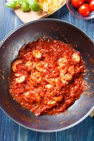 Gamberetti con salsa di pomodoro ed erbe su una pentola — Foto Stock