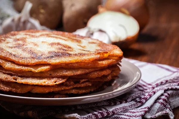 Kartoffelpuffer stapeln sich auf einem Holztisch. im Hintergrund po — Stockfoto