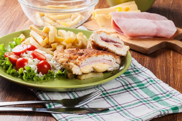 Schnitzel cordon bleu mit Schweinelende serviert mit Pommes und Salat — Stockfoto