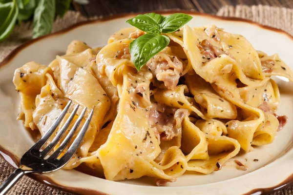 Bir plaka üzerinde jambon ve peynir soslu Pappardelle makarna — Stok fotoğraf