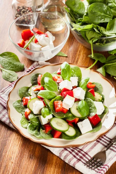 Salada de espinafre fresca com feta, pepino e páprica vermelha em um pla — Fotografia de Stock