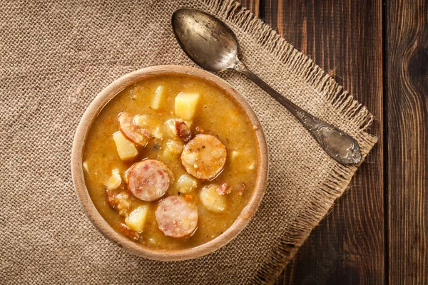 Дерев'яна миска з горіхового супу з ковбасою та картоплею — стокове фото
