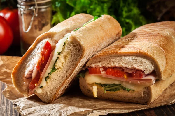 Ristet panini med skinke, ost og arugula sandwich - Stock-foto