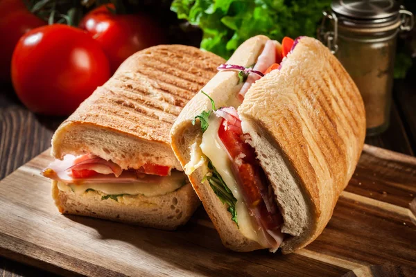 Panini torrado com sanduíche de presunto, queijo e rúcula — Fotografia de Stock