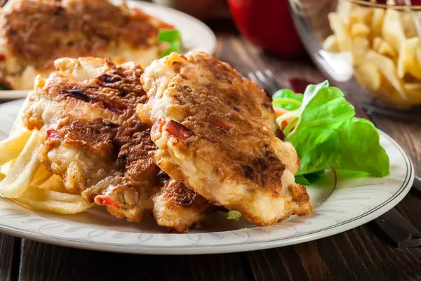 Chicken medallions with red peppers served with chips — Stock Photo, Image