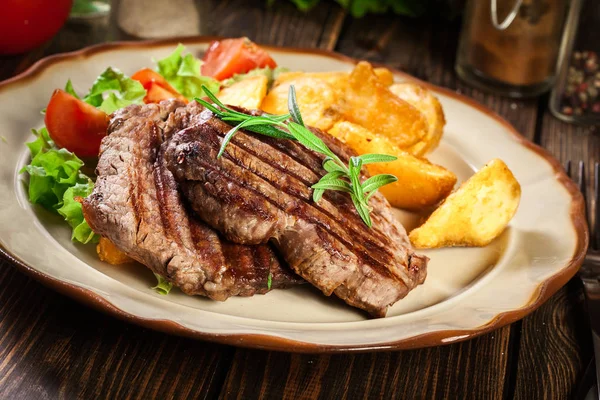 Suculentas porções de filé mignon grelhado servido com batatas assadas — Fotografia de Stock