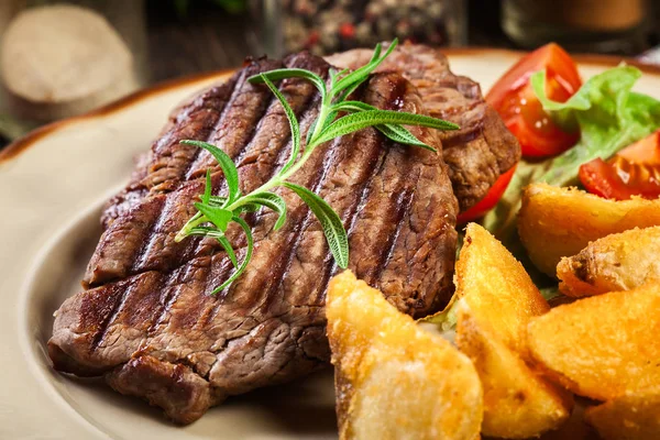 Succulent portions of grilled fillet mignon served with baked potatoes — Stock Photo, Image