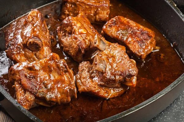 Costillas de cerdo de repuesto en el plato en salsa propia — Foto de Stock