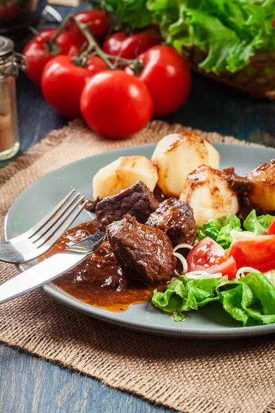 Varkensvlees vlees stoofpotje, geserveerd met aardappelen en groente salade — Stockfoto