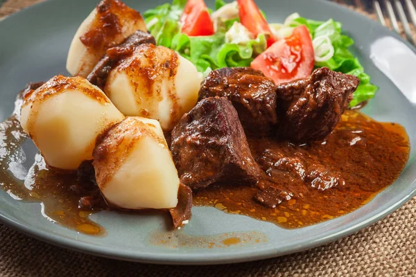 Stufato di carne di maiale servito con patate e insalata di verdure — Foto Stock