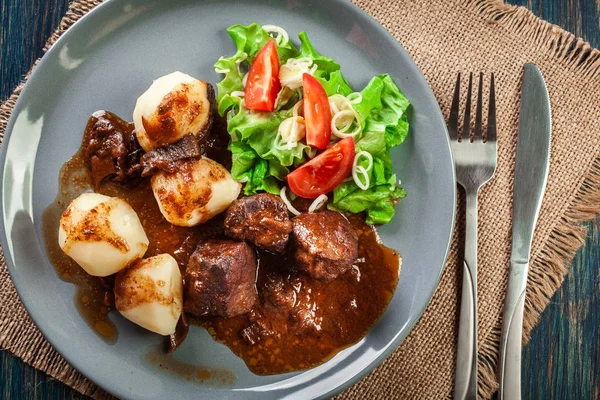 Pork meat stew served with potatoes and vegetable salad — Stock Photo, Image