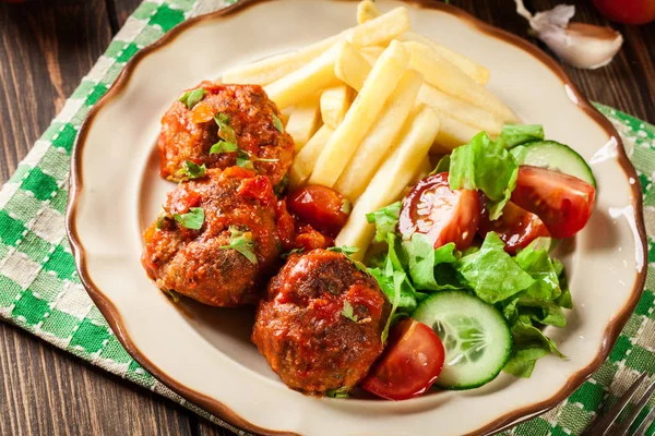 Almôndegas assadas em molho de tomate com batatas fritas e salada — Fotografia de Stock