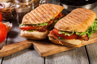 Toasted ciabatta sandwich with smoked bacon, cheese and tomato clipart
