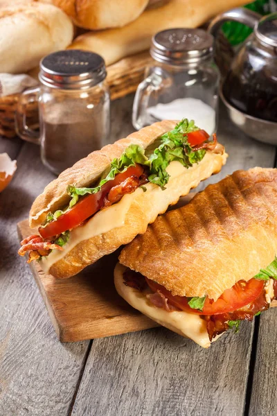 Toasted ciabatta sandwich with smoked bacon, cheese and tomato — Stock Photo, Image