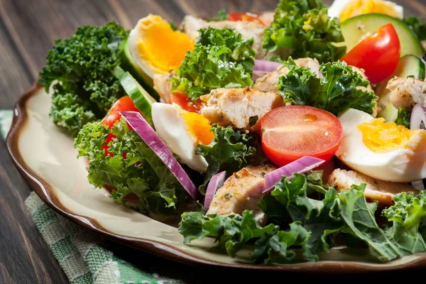 Ensalada fresca con pollo, tomates, huevos y lechuga en el plato —  Fotos de Stock