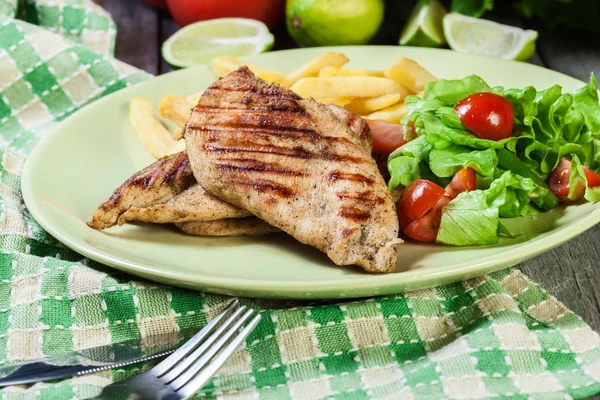 Grilled chicken breasts served with fries — Stock Photo, Image