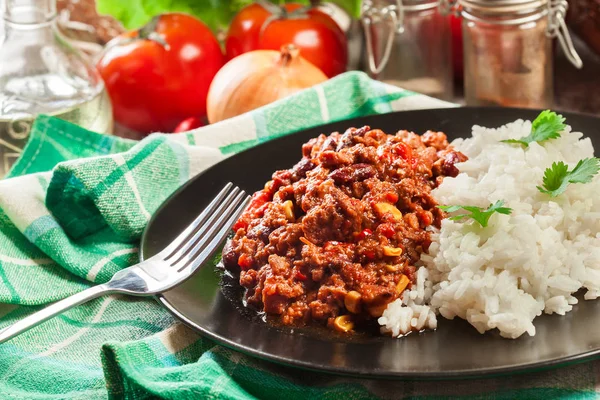 Chili con carne picante con carne molida, frijoles, tomates y maíz servido con arroz —  Fotos de Stock