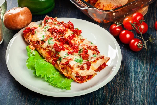 Tradiční mexické enchiladas s kuřecím masem, pikantní rajčatovou omáčkou a sýrem na talíři — Stock fotografie