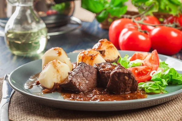 Varkensvlees vlees stoofpotje, geserveerd met aardappelen en groente salade — Stockfoto