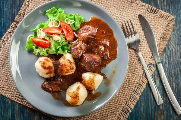 Pork meat stew served with potatoes and vegetable salad — Stock Photo, Image