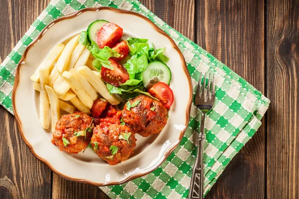 Kızarmış köfte, domates soslu patates kızartması ve salata ile — Stok fotoğraf