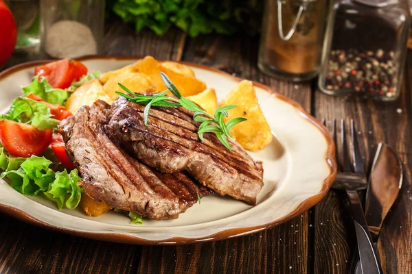 Sappige delen van gegrilde filet mignon geserveerd met gebakken aardappelen — Stockfoto