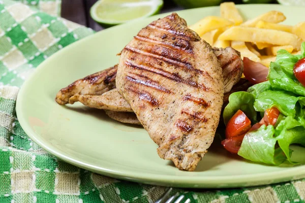 Grilled chicken breasts served with fries — Stock Photo, Image