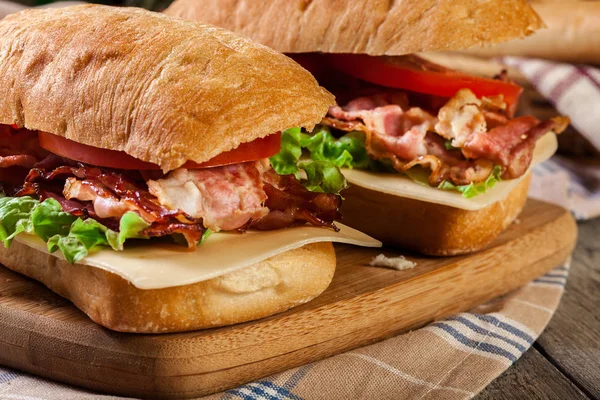 Ciabatta sandwich with smoked bacon, cheese and tomato — Stock Photo, Image