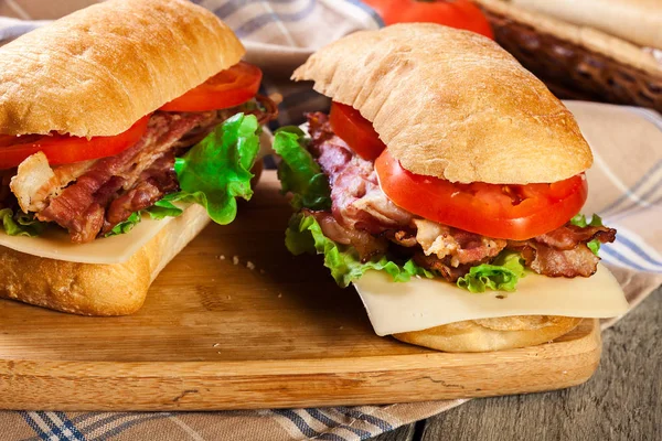 Ciabatta sandwich with smoked bacon, cheese and tomato — Stock Photo, Image