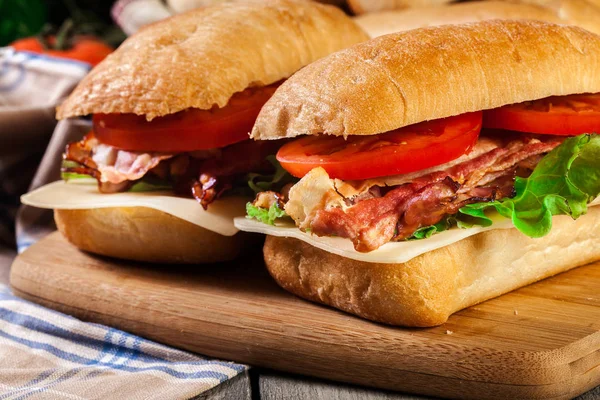 Ciabatta sandwich with smoked bacon, cheese and tomato — Stock Photo, Image