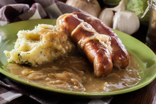 Bangers e Mash. Salsiccia al forno con sugo di cipolla — Foto Stock