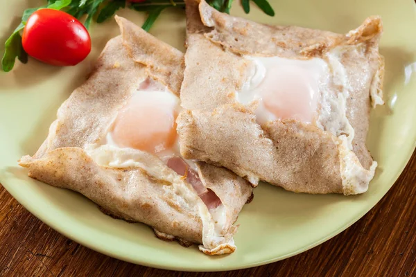 Crêpes mit Schinken, Käse und pochiertem Ei auf einem Teller — Stockfoto