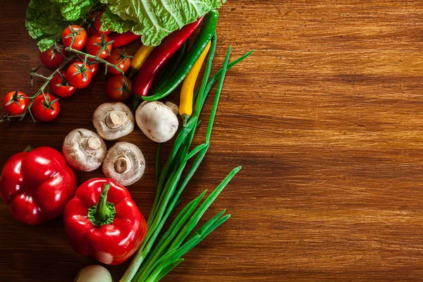 Bordas vegetais frescas no fundo de madeira — Fotografia de Stock