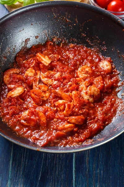 Креветки с томатным соусом и травами на сковороде — стоковое фото