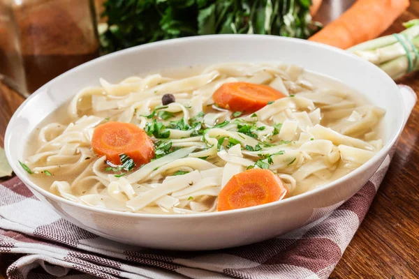 Tasty meat broth with noodles, carror and parsley — Stock Photo, Image