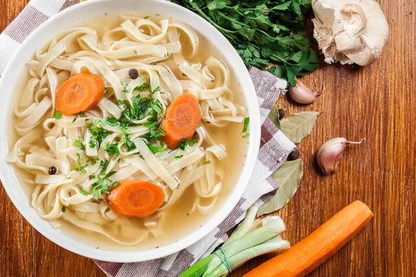 Tasty meat broth with noodles, carror and parsley — Stock Photo, Image